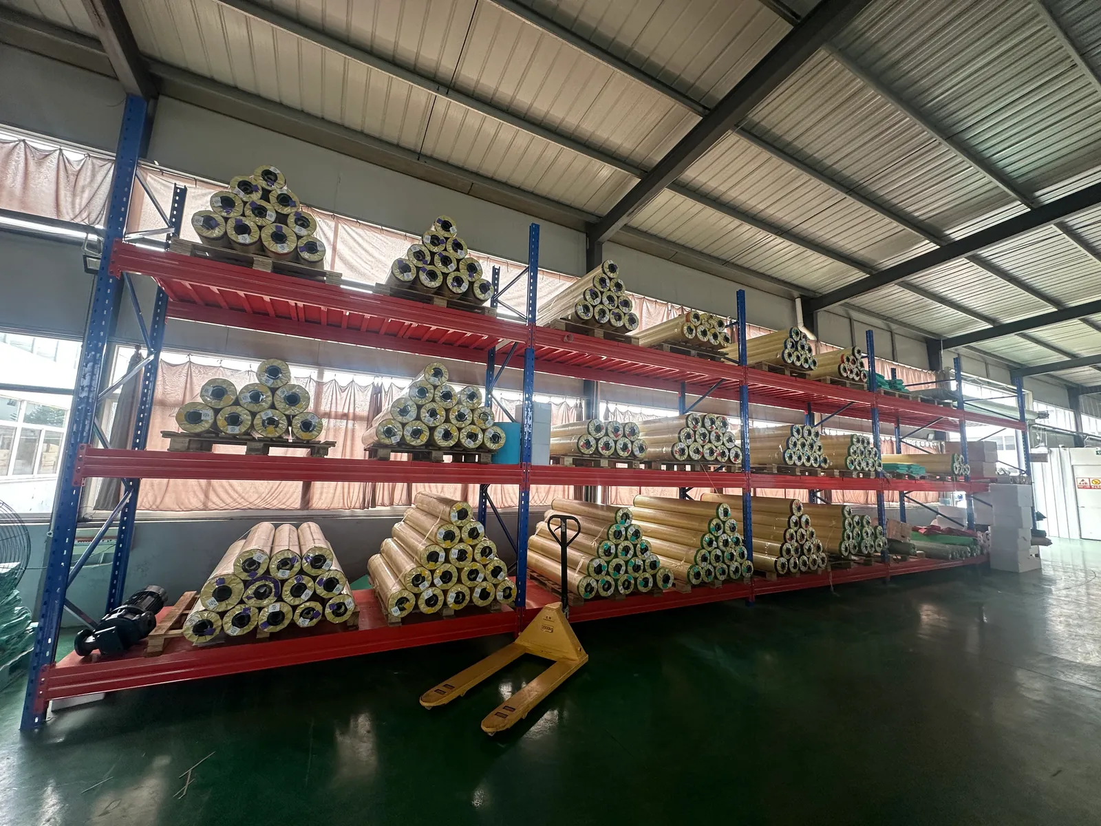 Racked rolls of coated cover fabric in the Tianshu material store